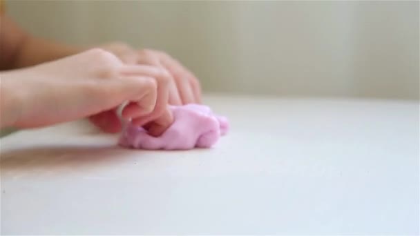 Child at the white table playing slimy pink Lizun HD 1920x1080 — Stock Video