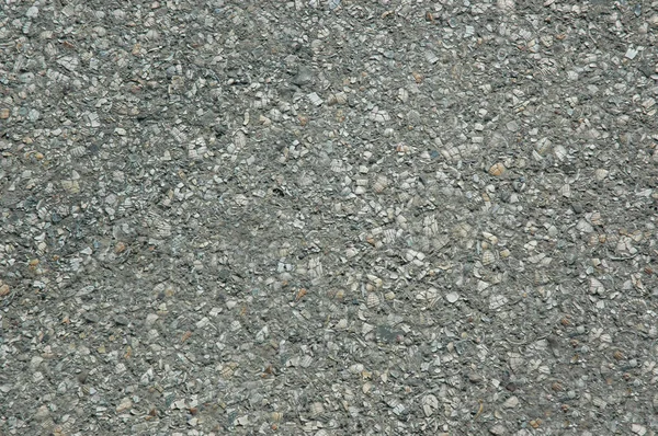 Carretera de asfalto con una superficie gris rugosa. Textura o fondo . — Foto de Stock