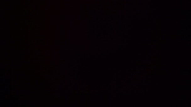 Blikající skvrny světle červené barvy na černém pozadí 4k — Stock video
