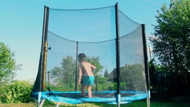 Мальчик летом в жаркий день прыгает на батуте на открытом воздухе HD 1920x1080 — стоковое видео