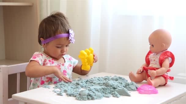 Маленька дитина в розплідник грає з кінетичним піском на білому столі HD — стокове відео