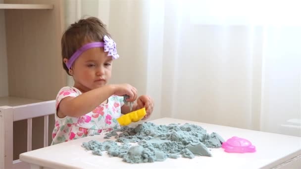 Bambina in abito floreale gioca con sabbia conica HD — Video Stock