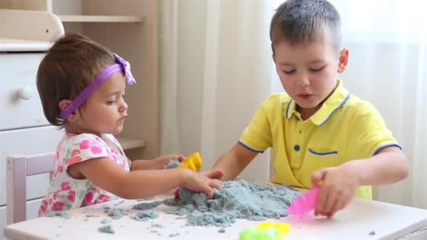 Fille et garçon jouent ensemble avec le sable cinétique à la maternelle à la table blanche HD 1920x1080 — Video