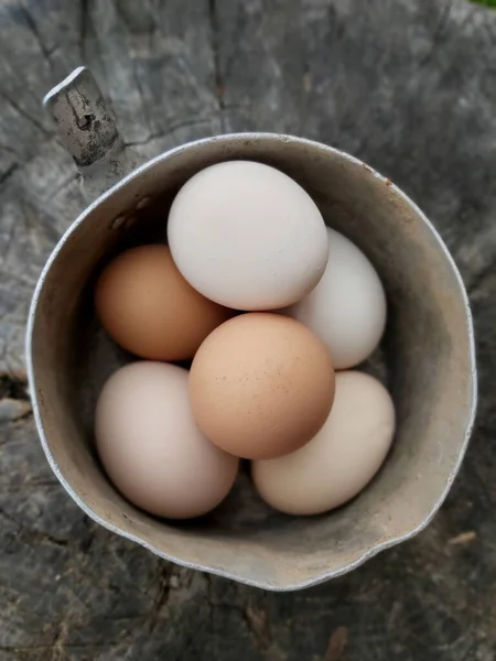 Village chicken eggs yellow and white lie in a pot .Texture or background — Stock Photo, Image