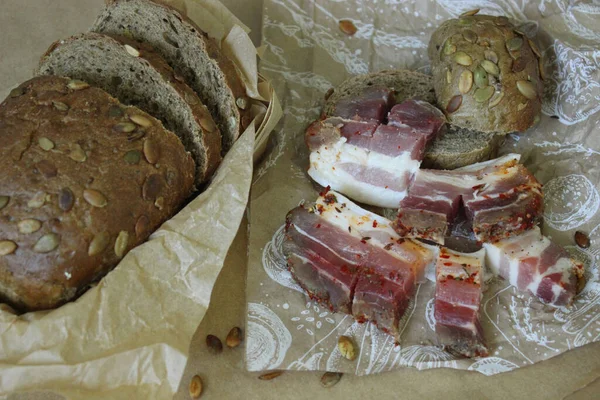 On paper slices of bread with slices of bacon and onions close up — Stock Image On paper slices of bread with slices of bacon and onions close up Stock Image