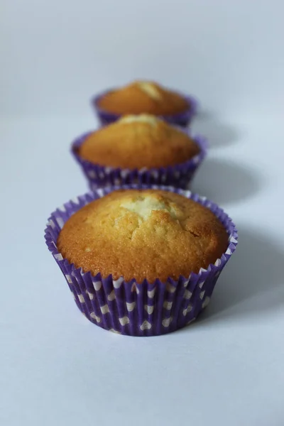 Postre casero para el té tres cupcakes en una envoltura azul —  Fotos de Stock