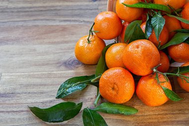 Clementines ahşap yüzeye yapraklarla