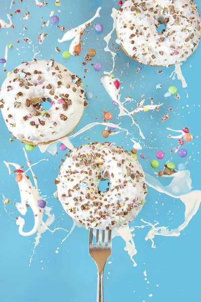 Floating in the air donuts on a blue background. Sweets, pastries.