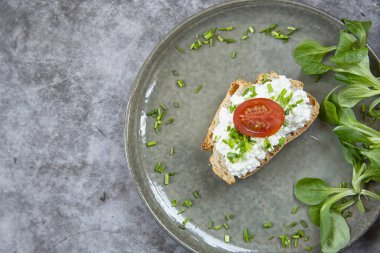 Kahvaltı. Yeşil soğan ve domates ile süzme peynir ile bulaşmış ekmek bir parça