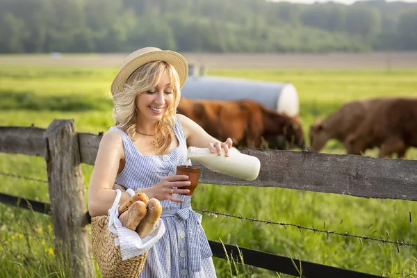 Dorfmädchen Gießt Milch Ein Glas Vor Dem Hintergrund Von Feldern — Stockfoto