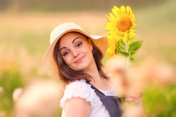 女性肖像户外 一个戴着草帽的女人 在花场上放日葵 夏天在村子里 — 图库照片