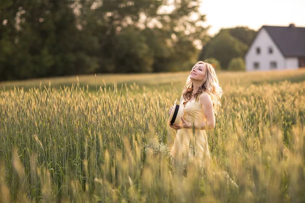 Apus de soare în timpul verii. O femeie tânără pe câmp aruncă o pălărie. Stilul rustic — Fotografie, imagine de stoc