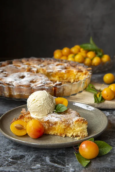 yellow plum mirabelle. Plum cake with a scoop of vanilla ice cream on a dark background. Summer fruit season.harvest.