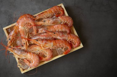 Kırmızı karides ahşap kutu siyah arka plan üzerinde büyük . üstten görünüm. Deniz ürünleri