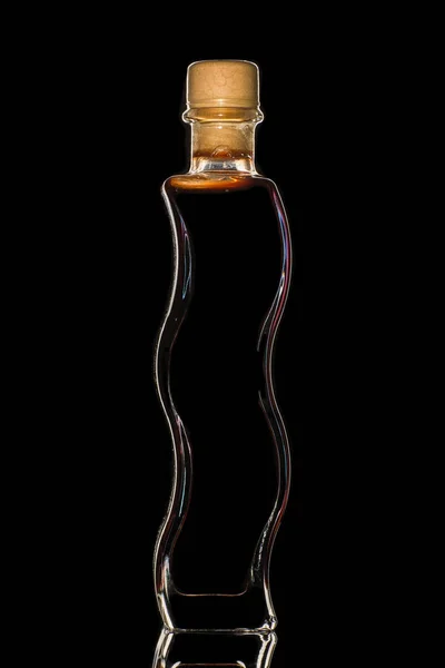 Une bouteille de vinaigre balsamique sur fond sombre et isolé . — Photo
