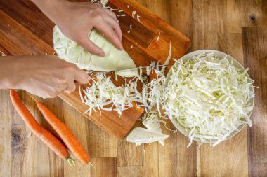 Yemek. sivri lahana. Tahta bir masada rendelenmiş lahana. Üretmek.