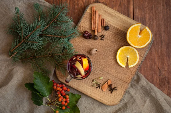 Üstten görünüm narenciye, tarçın, Kakuleden ve anason baharat ve köknar ile şarap mulled. Ahşap rustik arka plan üzerinde Noel rahat flatlay.