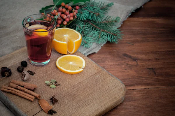 Görüş açısı narenciye, tarçın, Kakuleden ve anason baharat ve köknar ile şarap mulled. Ahşap rustik arka plan üzerinde Noel rahat natürmort.
