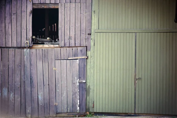 漂白納屋のドア 入り口のドアと開いた窓のハッチを持つ古い不安定で色あせた納屋のドア — ストック写真