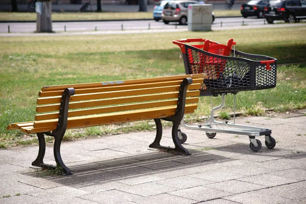 Carrello Della Spesa Accanto Alla Panca Del Parco Moderno Carrello — Foto Stock