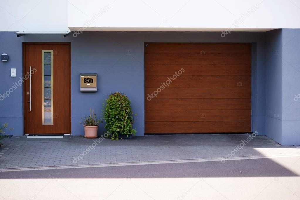 Entrance Modern town house / The wooden door and garage door of a modern town house.                           