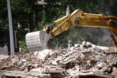 Yıkım, tarak / bir ekskavatör bir endüstriyel bina inşaat alanında standları ve enkaz kaldırır