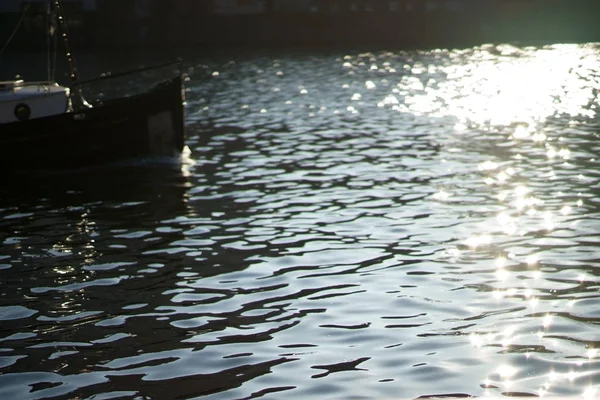 船在波光粼粼的阳光下穿过波光粼粼的水面 — 图库照片