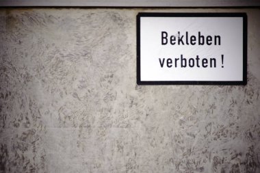 Uyarı işareti ile Billboard / bir Pano close-up yırtık kapalı hurda kağıt posterler ve tutkal kalıntı ve bir uyarı ile oturum: Hayır yapışmasını