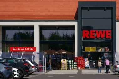 Rewe gıda pazarı / Nieder-Olm 26 Mayıs 2019 tarihinde şirket tabelası ve bitişik otopark ile bir Rewe mağazanın büyük modern giriş