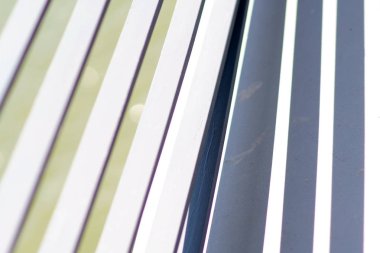 Demir payandalar gölgeleri gölgeler / Simetrik gölgeler atan bir köprü korkuluklarının beyaz boyalı çapraz çubuklarının yakın çekimi.