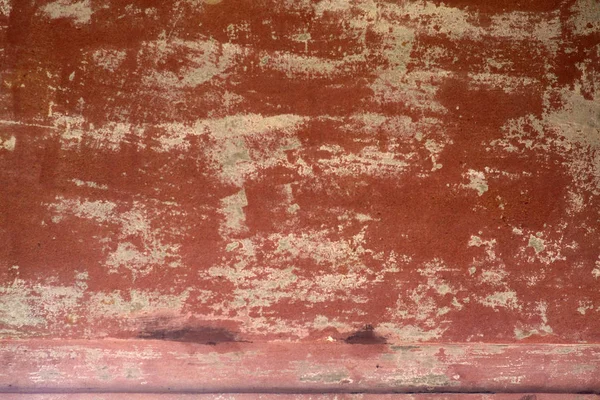 Flaking tone-colored wall paint / The close-up of peeling clay colored wall paint on a wall