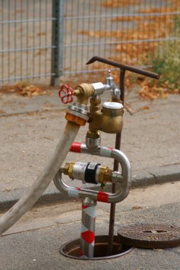Geçitte su pompalama istasyonu / Bir geçit kaldırımında su boruları ve bir su sayacı ile bir su pompalama istasyonu