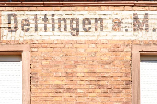 Ortsschild Dettingen Das Namensschild Der Stadt Dettingen Der Backsteinfassade Eines — Stockfoto