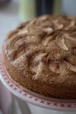 kırmızı bir süs ile beyaz bir tabak üzerinde elma pasta