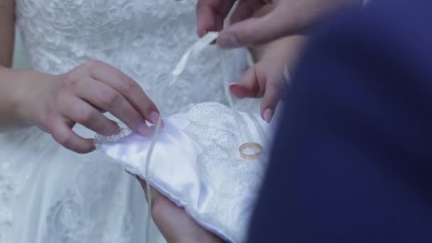 新郎从垫子上拿结婚戒指 放在新娘的手指上 — 图库视频影像