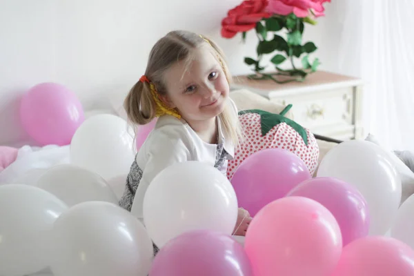Ένα Κορίτσι Παίζει Στο Κρεβάτι Λευκά Και Ροζ Μπαλόνια Και — Φωτογραφία Αρχείου