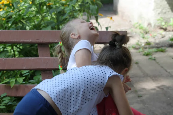 Dwie Dziewczyny Grają Śmiać Się Ławce Ogrodzie — Zdjęcie stockowe