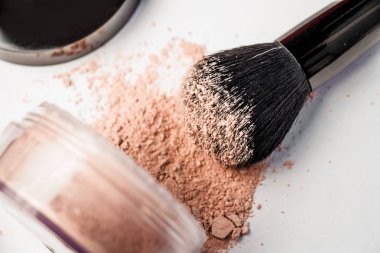 ters bir kavanoz, siyah makyaj fırçası dağınık toz