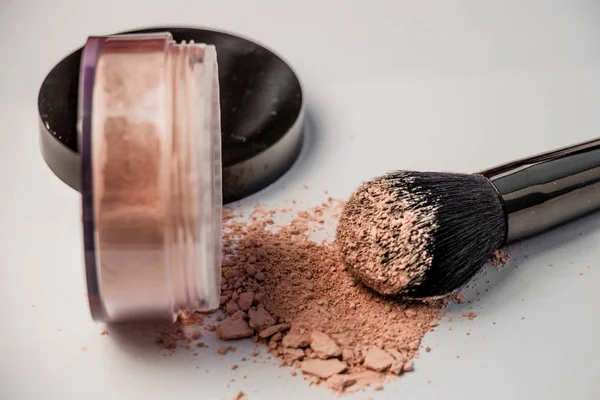 ters bir kavanoz, siyah makyaj fırçası dağınık toz