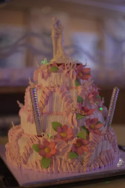 クリームから新婚夫婦 キャンドルや花のフィギュアとウェディングケーキ — ストック写真