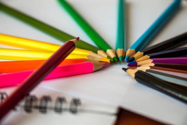 On beş çok renkli kalemler etrafında yatıyor ve bir kağıt beyaz levhalar üzerinde üstte