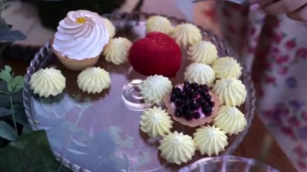 女人切一个心形的蛋糕 各种蛋糕在水晶圆盘 — 图库视频影像