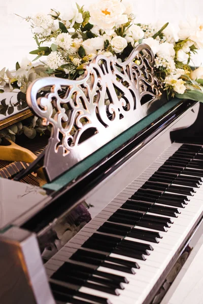 白いバラの花束で飾られたオープンキーのピアノ — ストック写真