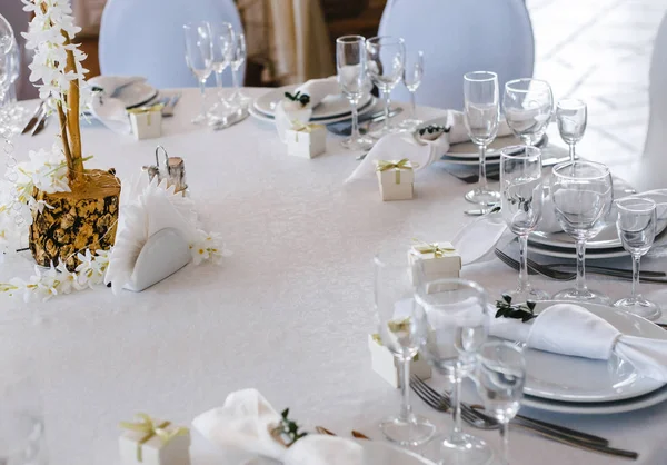 ziyafet masa ayarı, masanın ortasında beyaz çiçek bir buket ile dekore