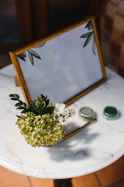 bir çerçeve içinde notlar için bir tabak, bir kalem, çiçek bir demet, masada boya iki kavanoz