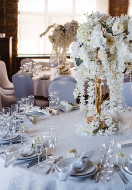 ziyafet yuvarlak masalar, masaların ortasında beyaz çiçek bir buket ile dekore