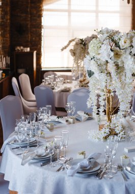 ziyafet yuvarlak masalar, masaların ortasında beyaz çiçek bir buket ile dekore