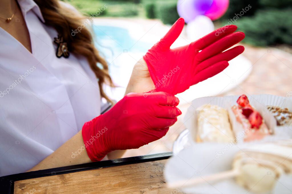 woman putting on red rubber gloves