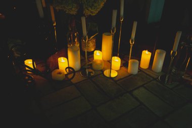 Yerde yanan mumlar var.