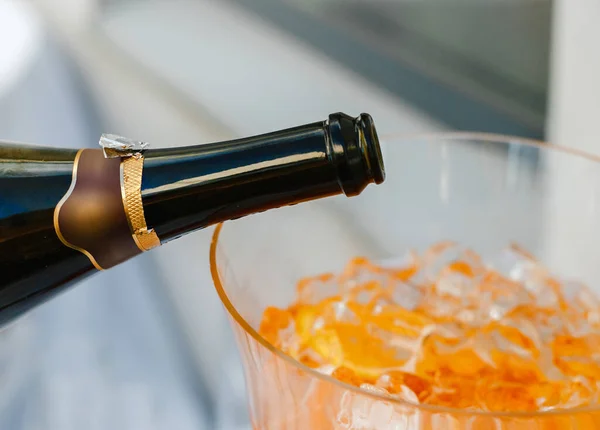 シャンパンを氷の入った大きなガラス容器に注ぎ — ストック写真